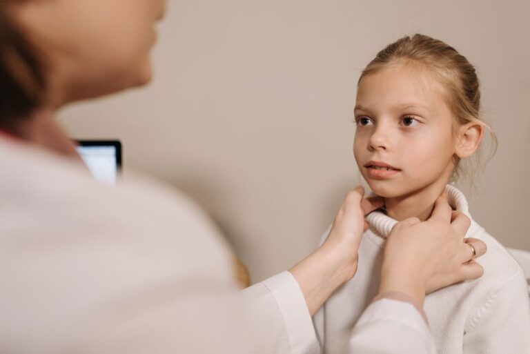 Medic pediatru consultând un copil în cabinet